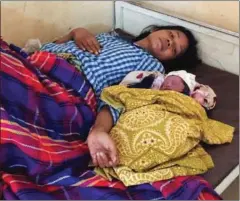  ?? SEN DAVID ?? Ny Chamrouen, 29, and her newborn baby rest at the Stung Meanchey Referral Hospital after she delivered the baby on Monivong Bridge yesterday morning in Phnom Penh.