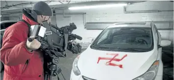  ?? THE CANADIAN PRESS FILES ?? A cameraman shoots a swastika painted on one of several cars on Feb. 24, 2015, in Montreal. Anti-Semitism is on the rise in the country, a Jewish advocacy group said Tuesday.