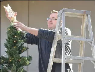  ?? NEWS PHOTO MO CRANKER ?? Top: Matthew Jubelius places a star on top of the Methanex Christmas tree Saturday at the Medicine Hat Lodge. A number of decorated trees will be on sale Nov. 17 to support the Santa Claus Fund.