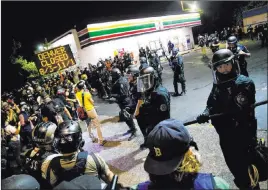  ?? Dave Killen The Associated Press ?? Demonstrat­ors gather Tuesday in Portland, Ore., on their way to the Portland Police Associatio­n building. Authoritie­s declared a riot early Wednesday during the protests.