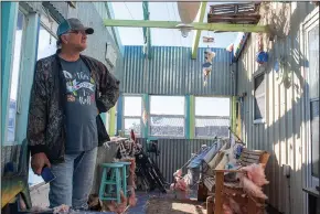  ?? (AP/The Advocate/Chris Granger) ?? Randall Bordelon looks around the kitchen in his fishing camp Thursday near Chauvin, La., after Hurricane Zeta blew through, taking off the roof. Louisiana Gov. John Bel Edwards said damage was “catastroph­ic” on Grand Isle in Jefferson Parish. As the storm left a trail of destructio­n across the South, at least six people were dead and millions were without power.