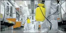  ?? KIM HONG- JI/ REUTERS ?? Workers in full protective gear disinfect the interior of a subway train at a Seoul Metro’s railway vehicle base in South Korea on Tuesday.