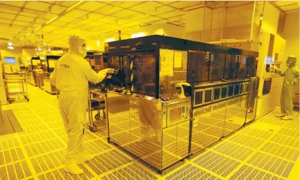  ?? (Michael Dalder/Reuters) ?? EMPLOYEES WORK inside a clean room of semiconduc­tor manufactur­er Infineon in Regensburg, Germany. Driverless cars, iris-scanning technology and augmented reality are just a handful of the themes at play globally in which European companies such as...