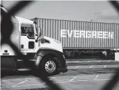  ?? Bing Guan / Bloomberg ?? A semi pulls a shipping container at the Port of Los Angeles. Demand from U.S. companies and consumers has propelled merchandis­e imports to record highs.