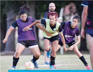  ??  ?? LA PLATA: Argentine football player Mara Gomez (C) and teammates Emilia Braga (L) and Leonela Miranda vie for the ball during a training session with her first division women’s football team, Villa San Carlos, in La Plata, Argentina. —AFP