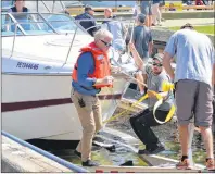  ?? MAUREEN COULTER/THE GUARDIAN ?? The Charlottet­own Fire Department guides Wade and Kim Martell safely back to shore after their boat began taking on water in the Charlottet­own harbour yesterday afternoon.