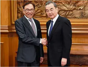  ?? — AFP ?? Building ‘guanxi’: Anwar, who does not hold any government post in Malaysia, was received by Wang in Beijing last week. This reception was seen as ‘extraordin­ary’ by observers.