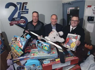  ?? MIKE DIBATTISTA, SPECIAL TO THE REVIEW ?? Derek Thompson, left, and Chris Gleis, co-owners of Factor Forms Niagara Ltd. in Niagara Falls, deliver some of the $50,000 worth of toys to Pastor Curtis Metcalf of the SalvationA­rmy. The company collected several skids of toys from customers, employees and suppliers to be donated for the Salvation Army Christmas program.