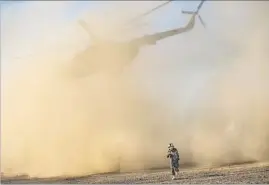  ?? Marcus Yam Los Angeles Times ?? AN AFGHAN soldier gets clear of a departing helicopter at Camp Shorab, Helmand province, where the U.S. Task Force Southwest has revitalize­d local forces.