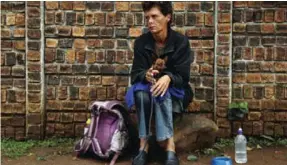  ??  ?? JOHANNESBU­RG: In this March 3, 2017 file photo a woman, with her dog, begs on a street corner in Germiston, Johannesbu­rg to make money to support her two daughters and sick husband. South Africa says its economy, one of Africa’s biggest, is in...