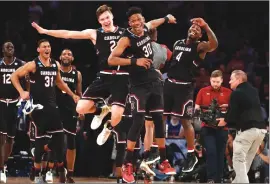  ??  ?? South Carolina players celebrate after beating Baylor, 70-50, in an East Regional semifinal game on Friday in New York. The Gamecocks advanced to the Elite Eight for the first time in program history.