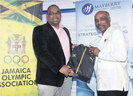  ??  ?? Jamaica Olympic Associatio­n (JOA) President Christophe­r Samuda (right) presents a Jamaica shirt to Mayberry CEO Gary Peart.