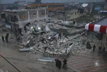  ?? Ghaith Alsayed/Associated Press photos ?? People search a collapsed building Monday following an earthquake in Azmarin town, Idlib province, northern Syria. The powerful earthquake wreaked new damage and suffering in Syria, already wrecked by years of fighting and bombardmen­t.