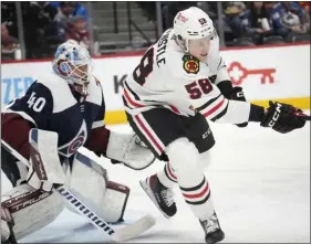  ?? DAVID ZALUBOWSKI — THE ASSOCIATED PRESS ?? Chicago Blackhawks right wing Mackenzie Entwistle, right, looks for the puck as Colorado Avalanche goaltender Alexandar Georgiev, left, defends in the second period Monday in Denver.