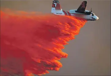  ?? Allen J. Schaben Los Angeles Times ?? A CAL FIRE airplane drops fire retardant near Cal State San Marcos in 2014. Though the sight of air tankers fills residents with hope, critics say they are too vulnerable to the extreme smoke and winds of recent fires.