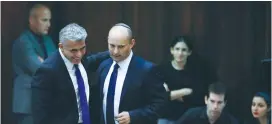  ?? (Baz Ratner/Reuters) ?? YESH ATID CHAIRMAN Yair Lapid (left) and his Bayit Yehudi counterpar­t, Naftali Bennett, then partners in the coalition, walk together at the Knesset in 2013.