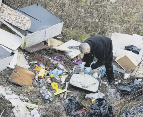  ?? ?? INVESTIGAT­ION: A council community Safety Warden at a fly tipping hot spot in Pellon, Halifax