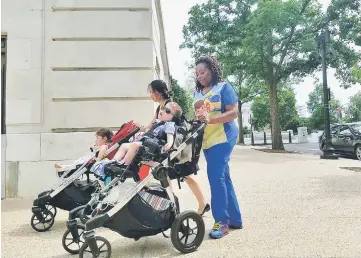  ??  ?? Hung pushes her two-year-old daughter, Xiomara, alongside Crowely, who is the caregiver to three-year-old Pierce, as they try to meet with senators on Capitol Hill to show how cuts to care that the Affordable Care Act provides would affect them.