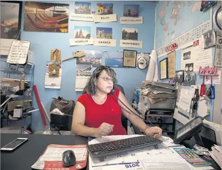  ?? Allen J. Schaben Los Angeles Times ?? SYLVIA AREVALO, who runs a Santa Ana travel agency that caters to Salvadoran­s, helps a client over the phone on May 26. She said she’s seen a 25% to 30% drop in ticket sales to El Salvador since President Trump was sworn in.