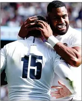  ??  ?? WHITE HOT: Daly is congratula­ted for his try by Cokanasiga, who went over for two of his own