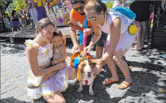  ?? Silvia Izquierdo
The Associated Press ?? Revelers pet a costumed dog during the Blocão dog Carnival parade Saturday in Rio de Janeiro, Brazil.