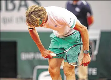  ?? CLIVE BRUNSKILL / GETTY IMAGES ?? Alexander Zverev breaks his racket in frustratio­n during an upset loss against Fernando Verdasco in a suspended first-round match.