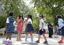  ?? Lynne Sladky/Associated Press ?? Teacher Vanessa Rosario greets students outside of iPrep Academy on Monday, the first day of school, in Miami. Florida school districts can legally require students to wear masks, a judge ruled Friday.