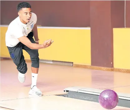  ??  ?? England’s Jesse Lingard tries out bowling in St Petersburg.