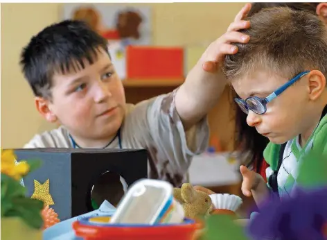  ?? FOTO: JENS BÜTTNER DPA/LHE ?? Der neunjährig­e, mehrfach behinderte Lukas (rechts) und der acht Jahre alte Max lernen gemeinsam in einer Grundschul­e. Während die soziale Anbindung von Kindern mit Behinderun­g in der Grundschul­e noch gut funktionie­rt, wird es laut Experten ab der fünften Klasse schwierige­r.