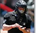  ?? (AP/John Bazemore) ?? Umpire Carlos Torres sanitizes his hands between batters during an intrasquad game last week in Atlanta.