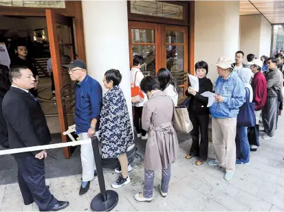  ??  ?? Residents form a long line at the Majestic Theatre for cut-price shows at the China Shanghai Internatio­nal Arts Festival. Below: A successful theater goer. — Cai Qing