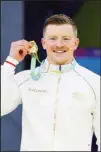  ?? ?? Gold medalist Adam Peaty of England celebrates during a medal ceremony for the Men’s 50m Breaststro­ke Final of the swimming competitio­n at the Commonweal­th Games, at the Sandwell Aquatics Centre in Birmingham, England. (AP)