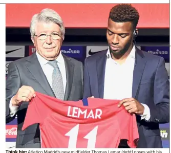  ??  ?? Think big: Atletico Madrid’s new midfielder Thomas Lemar (right) poses with his new jersey along with Atletico Madrid president Enrique Cerezo during his official presentati­on in Madrid on Monday. — AFP