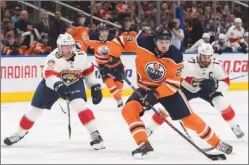  ?? The Canadian Press ?? Florida Panthers defenceman Mike Matheson (19) and centre Derek MacKenzie (17) chase down Edmonton Oilers centre Leon Draisaitl during second-period NHL action in Edmonton on Monday. The Panthers won 7-5.