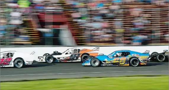  ?? SARAH GORDON/THE DAY ?? Cars move past the grandstand­s during Saturday’s SK Lite Modifieds qualifying race on opening day of the New London-Waterford Speedbowl.