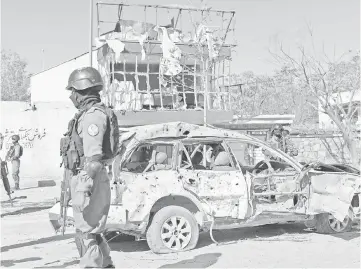  ??  ?? Afghan policemen stand at the site where a suicide bomber targeted a vehicle convoy of Afghan lawmakers in Kabul. — AFP photo