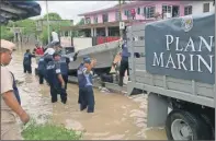  ??  ?? Marinos bajan una lancha para auxiliar a los damnificad­os por las inundacion­es generadas por el frente frío número 6 en Álamo, Veracruz