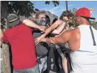  ?? NATHAN HOWARD/GETTY IMAGES ?? A Black Lives Matter protester scuffles with attendees of a pro-Trump rally during an event held to show support for the president in Clackamas, Ore., in August.