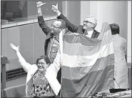  ?? AP/MICK TSIKAS ?? Members of Australia’s Parliament (from left) Cathy McGowan, Adam Brandt and Andrew Wilkie celebrate the House of Representa­tives’ passage Thursday of the same-sex marriage bill.