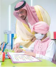  ??  ?? الأمير فيصل بن مشعل متابعا طفلة بالمرسم