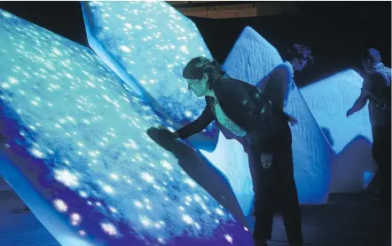  ?? POSTMEDIA FILES ?? A woman reaches out to touch the real icebergs that have scenes of the Arctic displayed on them. The icebergs are part of the Canadian Museum of Nature’s new permanent Canada Goose Arctic Gallery, with over 200 specimens and artifacts, including a...