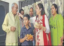  ?? HT PHOTO ?? Relatives offering sweets to Sanjeev Rajput’s father KL Rajput at his house in Jagadhri, Yamunanaga­r, on Tuesday.