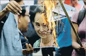  ?? BIKAS DAS / AP ?? Indignació­n Manifestan­tes izquierdis­tas queman un retrato de Aung San Suu Kyi frente al consulado de Birmania en Calcuta, India