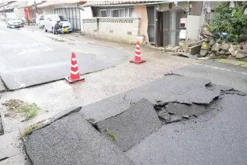  ??  ?? This photo released by the Shimane Nichinichi Shimbun via Jiji Press shows the tarmac along a street damaged by a earthquake in the city of Oda, Shimane prefecture. — AFP photo