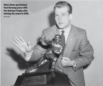  ?? AP FILES ?? Notre Dame quarterbac­k Paul Hornung poses with the Heisman Trophy after winning the award in 1956.