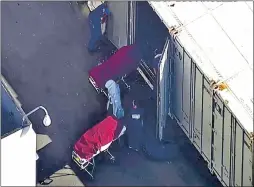  ?? ABC7 LOS ANGELES VIA AP ?? This photo from video provided by ABC7 Los Angeles shows workers putting bodies into a refrigerat­ed trailer at the offices of the Los Angeles County Coroner in Los Angeles on Jan. 8, 2021.