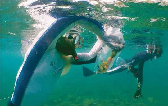  ?? ALEX LINDBLOOM/AP PHOTOS 2021 ?? Made Partiana, left, used to catch fish using cyanide. He eventually became part of a group taught to use nets and patrol the area to guard against cyanide use.