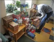  ?? RICK KAUFFMAN — DIGITAL FIRST MEDIA ?? Jacques Cooper, of POWER Home Remodeling, helps organize products that he and coworkers dropped off at the Wesley House on Monday.