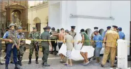  ?? PTI ?? Sri Lankans carry a dead body following a blast at the St. Anthony’s Church in Colombo, Sri Lanka, Sunday