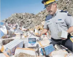  ?? TED JACOB/ POSTMEDIA NEWS ?? RCMP Sgt. Patrick Webb prepares to destroy contraband cigarettes.